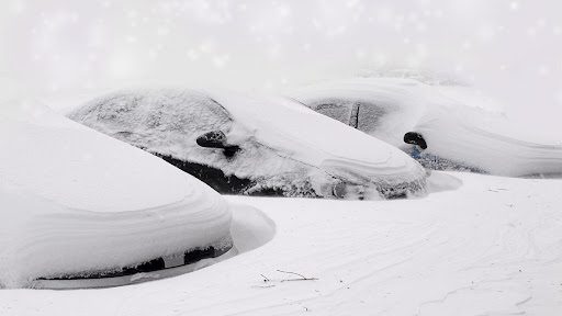 car buried in snow with a survival kit highlighted car buried in snow with a survival kit highlighted